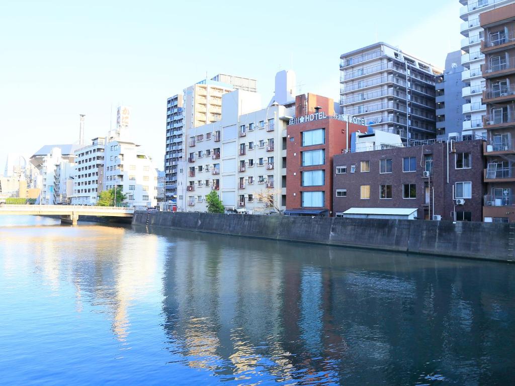 a body of water in a city with buildings at Sakuragawa River Side Hotel in Osaka