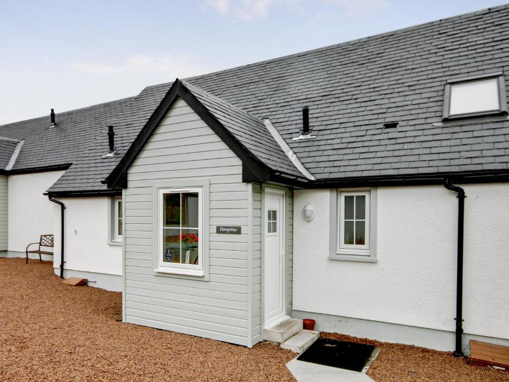 a white house with a black roof at Peregrine Cottage in Cambusbarron