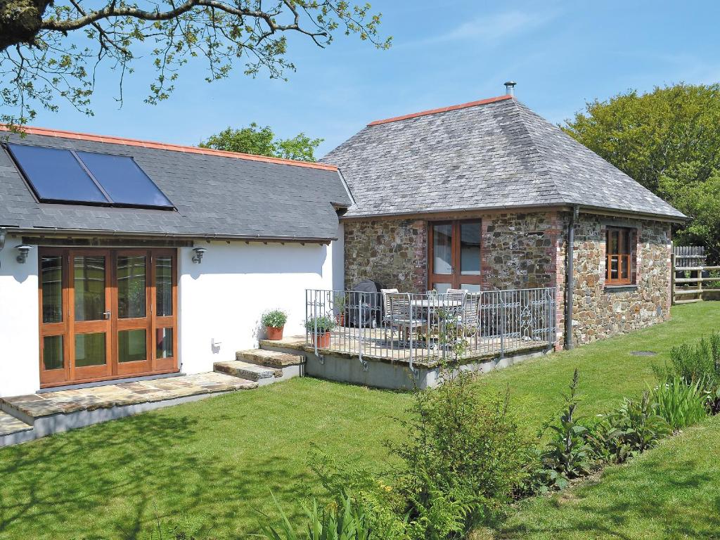 a stone house with a solar roof and a yard at Jacks Barn - Hssu in Welcombe
