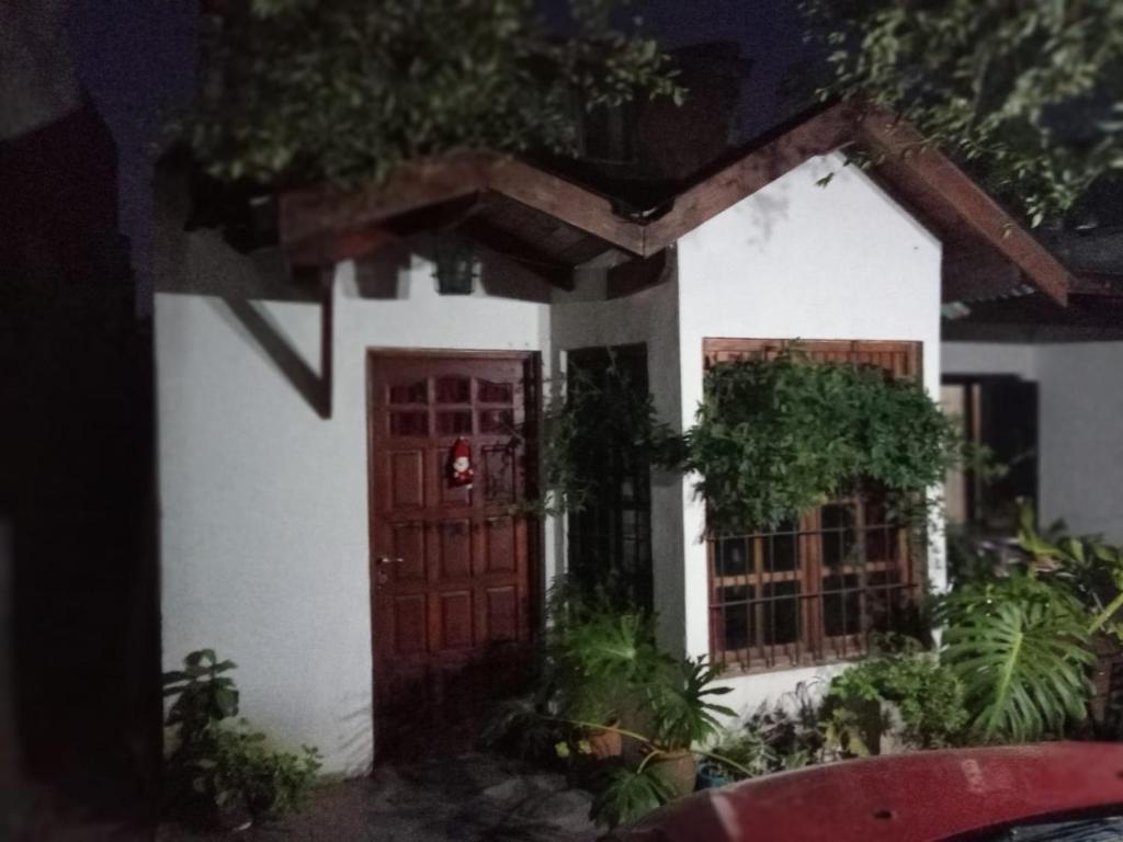 una pequeña casa blanca con una puerta roja en DUPLEX BARRIO CONSTITUCIÓN A 6 CUADRAS DE LA PLAYA en Mar del Plata