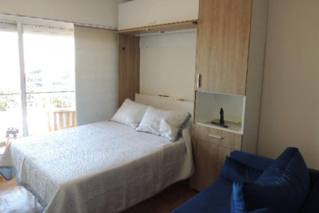 Un dormitorio con una cama y una silla azul. en MONOAMBIENTE VISTA AL RIO, en Florida