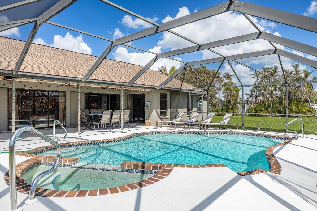 a swimming pool in a house with a large glass wall at Heated Pool, Sleeps 8 - Villa Sunny Daze in Cape Coral
