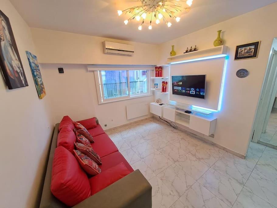 sala de estar con sofá rojo y TV en Departamento de Lujo en la Ciudad Buenos Aires en Buenos Aires