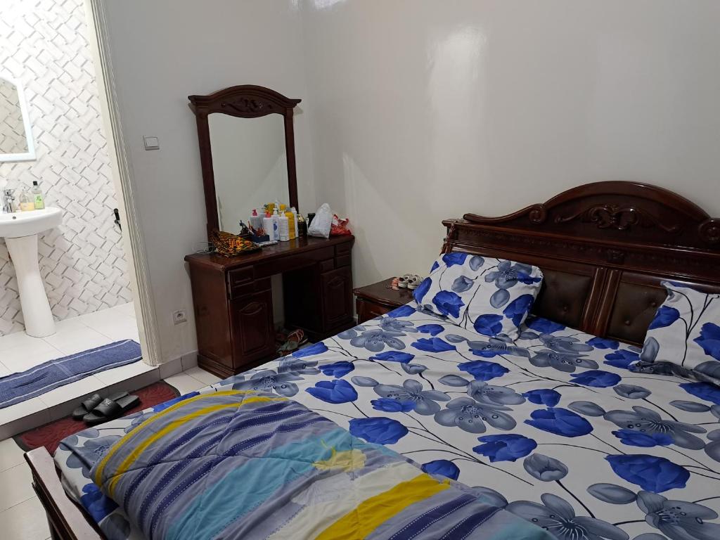 a bedroom with a bed and a sink and a mirror at Hann Mariste in Dakar
