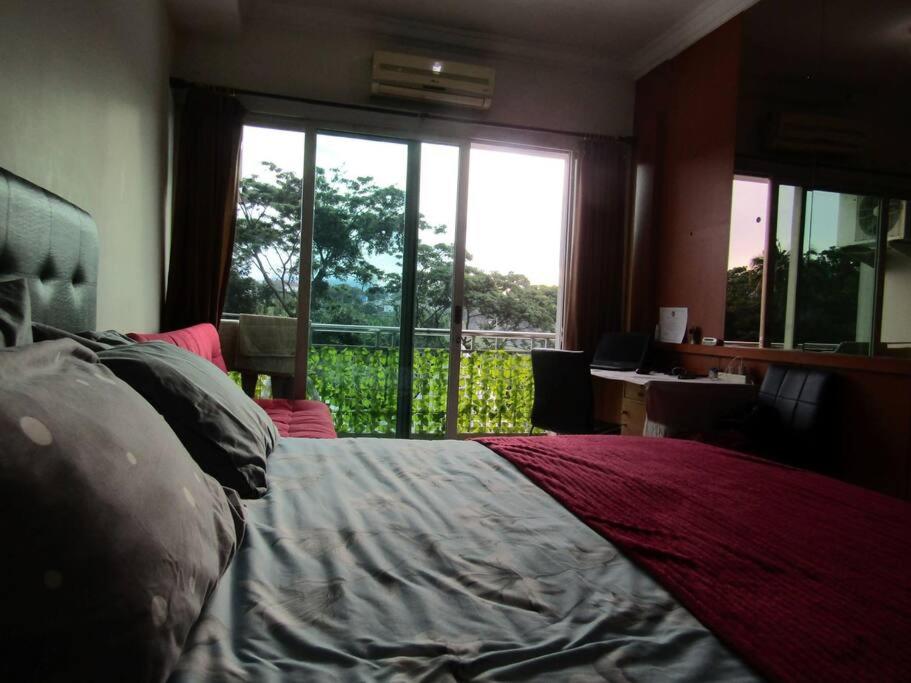 een slaapkamer met een bed, een bureau en een raam bij Quiet Room Near UNPAR, ITB. Ideal for students in Bandung
