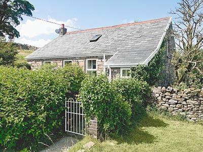 Casa de piedra con puerta y pared de piedra en Chapel Cottage, en Pont Sticill