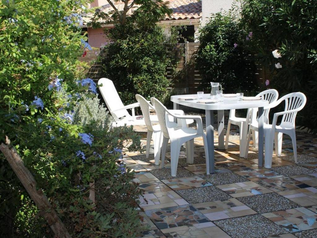 einen weißen Tisch und Stühle im Garten in der Unterkunft Appartement Gruissan, 2 pièces, 4 personnes - FR-1-229-98 in Gruissan