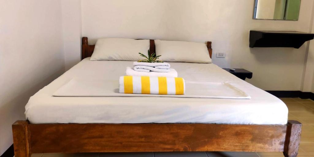 un letto con un vassoio e gli asciugamani di Ginto Residence - City Center a Coron