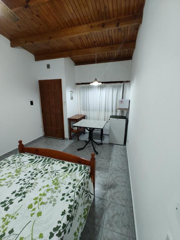 Un dormitorio con una cama y una mesa en una habitación. en Alojamiento Turistico Mainque, en Las Grutas