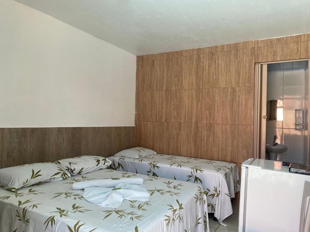 伊列烏斯的住宿－Pousada Savoya，一间卧室配有两张带白色床单的床