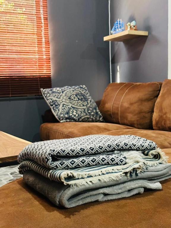 einen Haufen Decken auf einer Couch in der Unterkunft 2BR Apartment near Etosha in Katutura