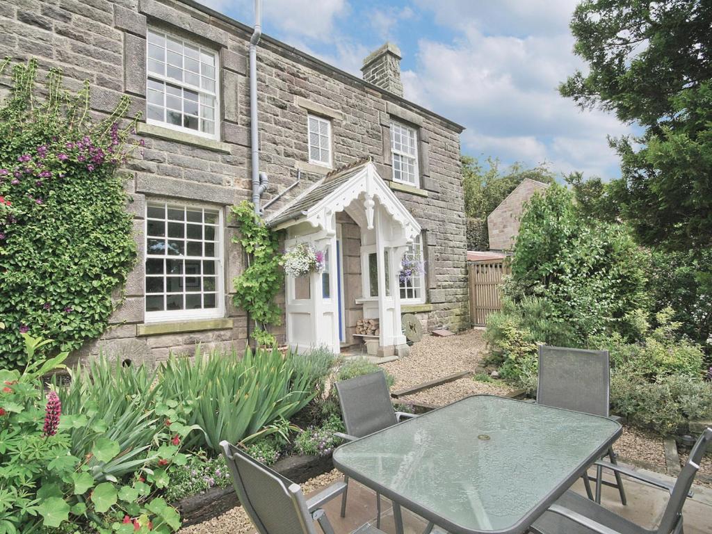 a table and chairs in front of a stone house at West View Cottage - E5386 in Two Dales