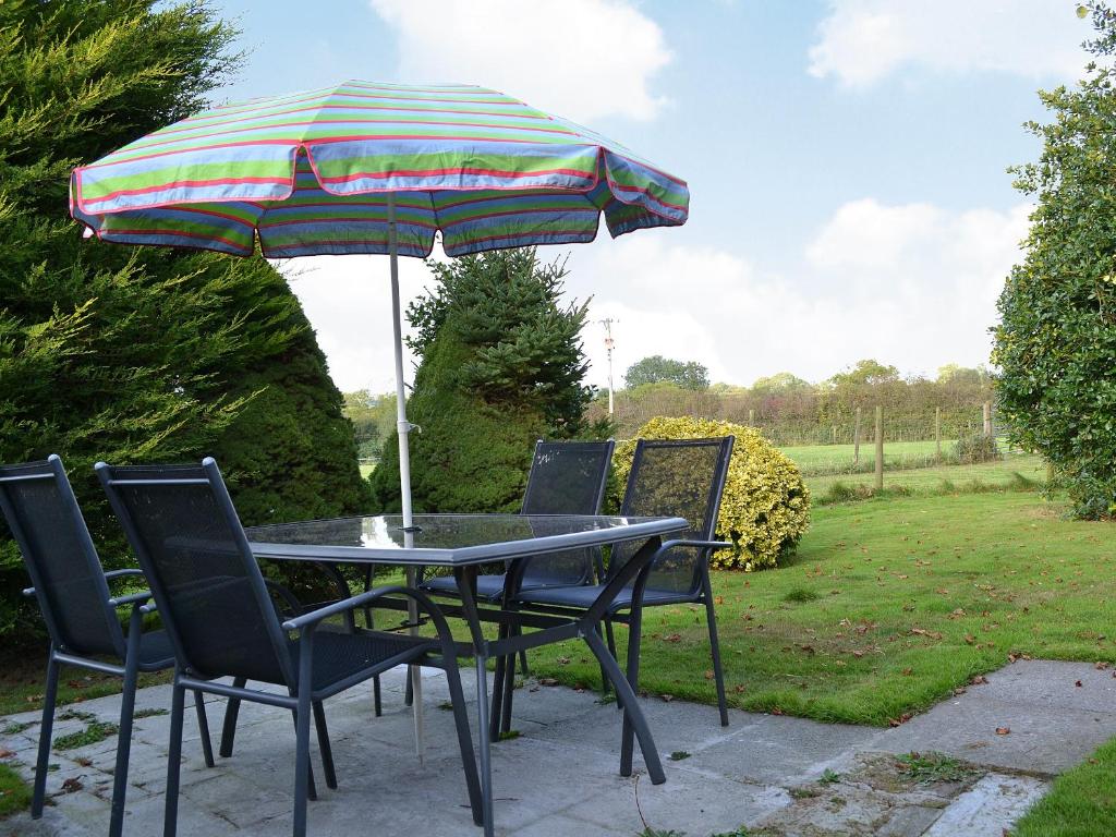 - une table et des chaises avec un parasol dans la cour dans l'établissement Ty Clyd - Hw7657, à Walton East