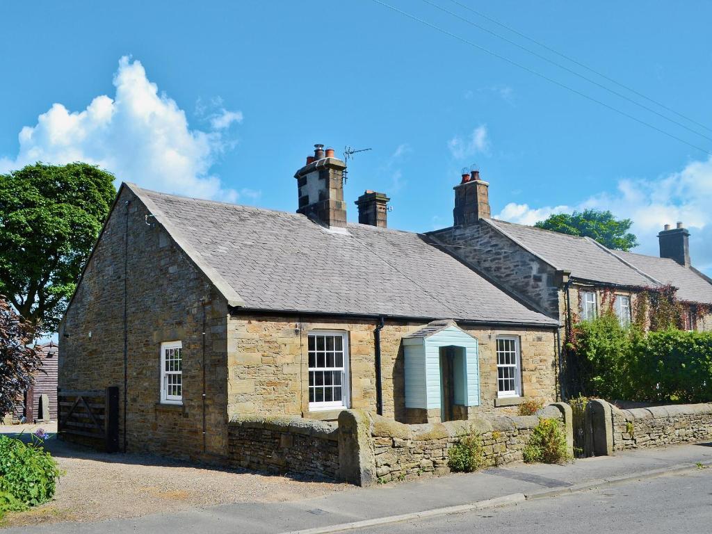 an old stone house on the side of a street at The Cottage in Stocksfield