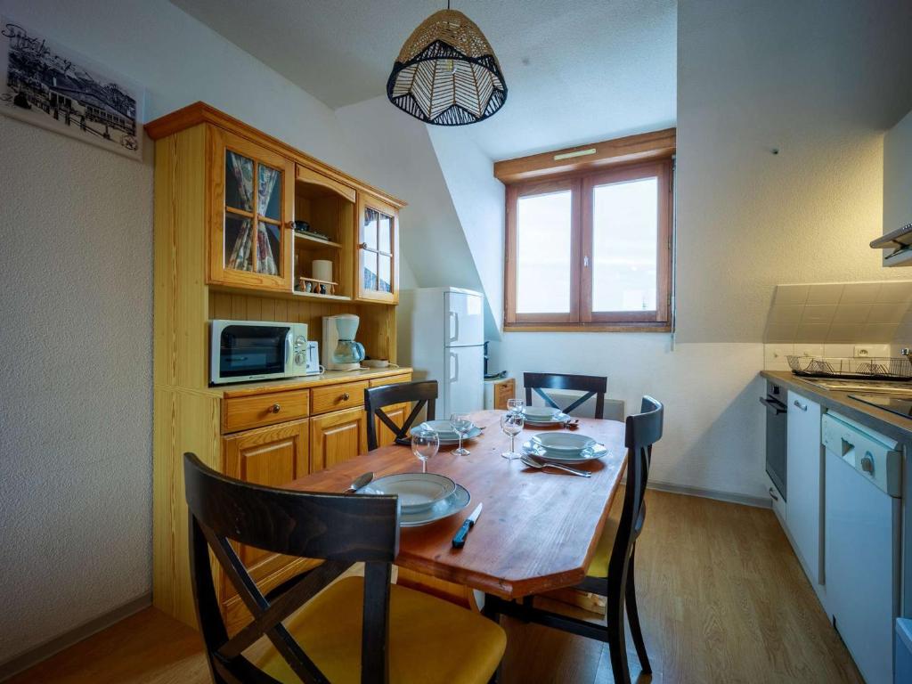 a kitchen with a wooden table with chairs and a dining room at Appartement Saint-Lary-Soulan, 1 pièce, 6 personnes - FR-1-296-454 in Saint-Lary-Soulan