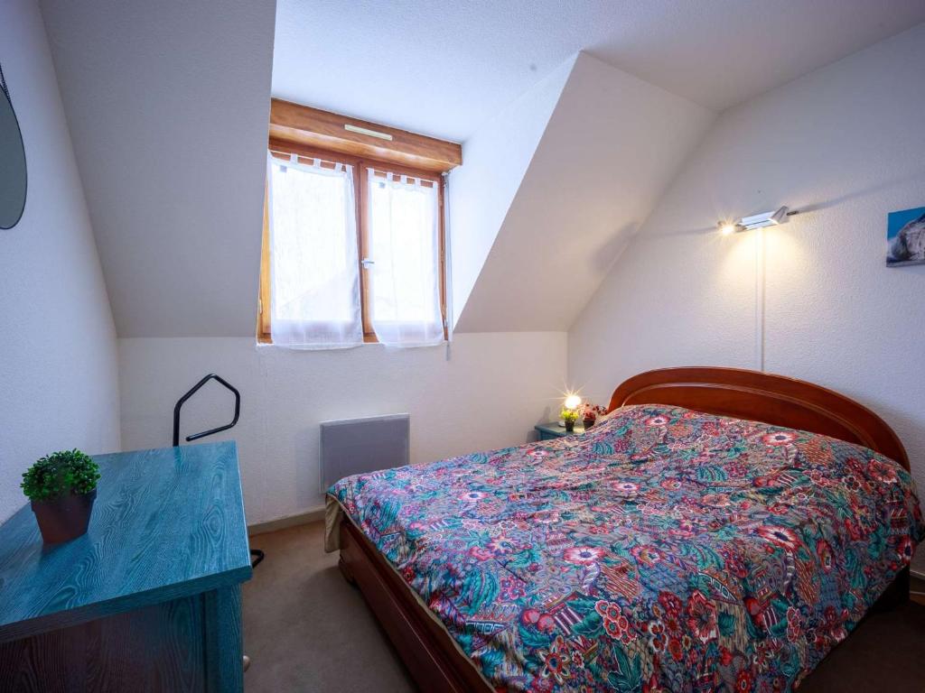 a bedroom with a bed and a table and a window at Appartement Saint-Lary-Soulan, 1 pièce, 6 personnes - FR-1-296-454 in Saint-Lary-Soulan