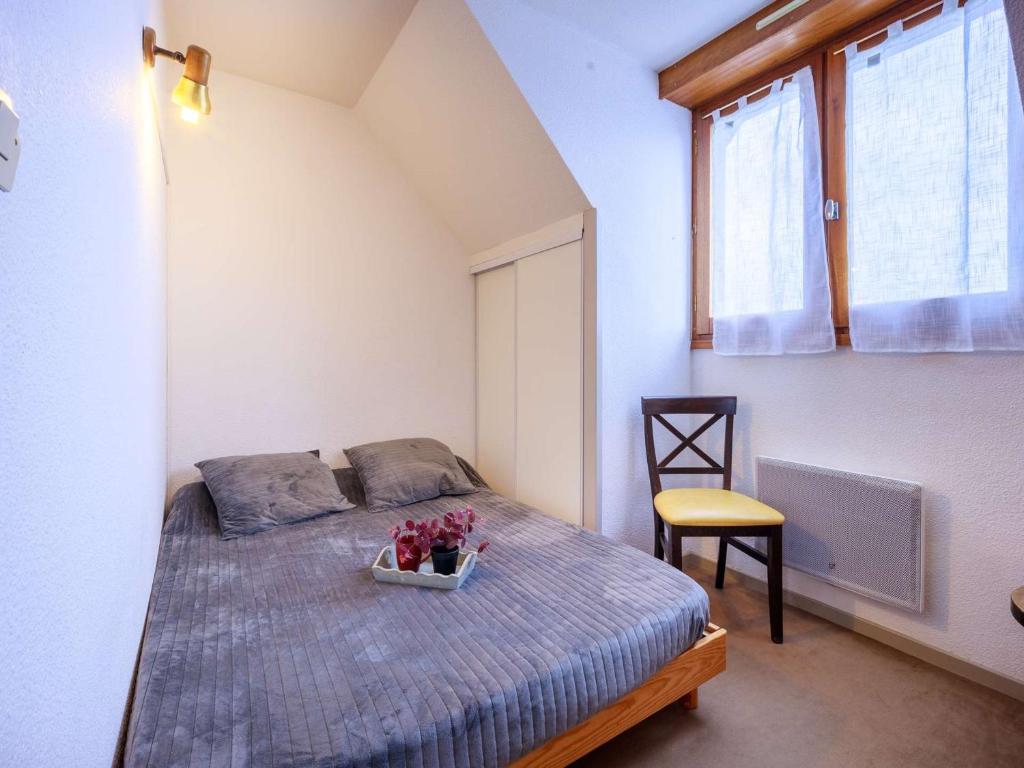 a bedroom with a bed with a bowl of flowers on it at Appartement Saint-Lary-Soulan, 1 pièce, 6 personnes - FR-1-296-454 in Saint-Lary-Soulan