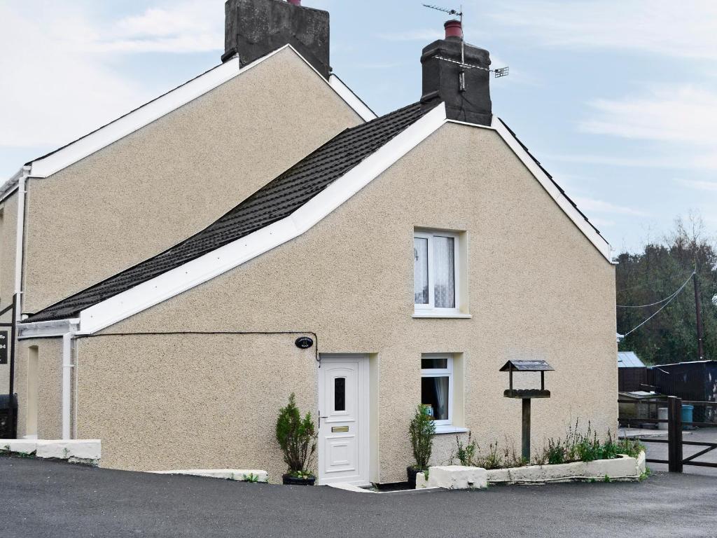 a large brick house with a white door at The Cottage in Cross Hands