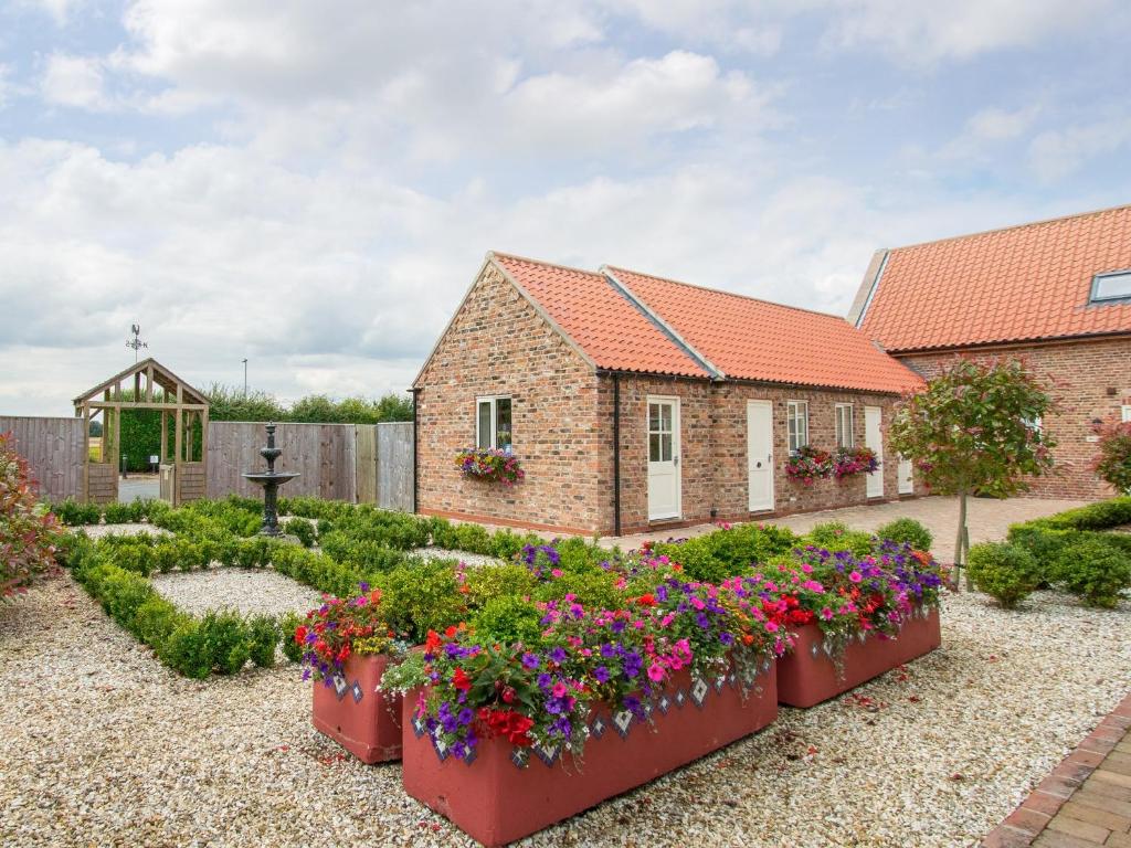 a garden with flowers in front of a house at Nursery Cottage in North Somercotes