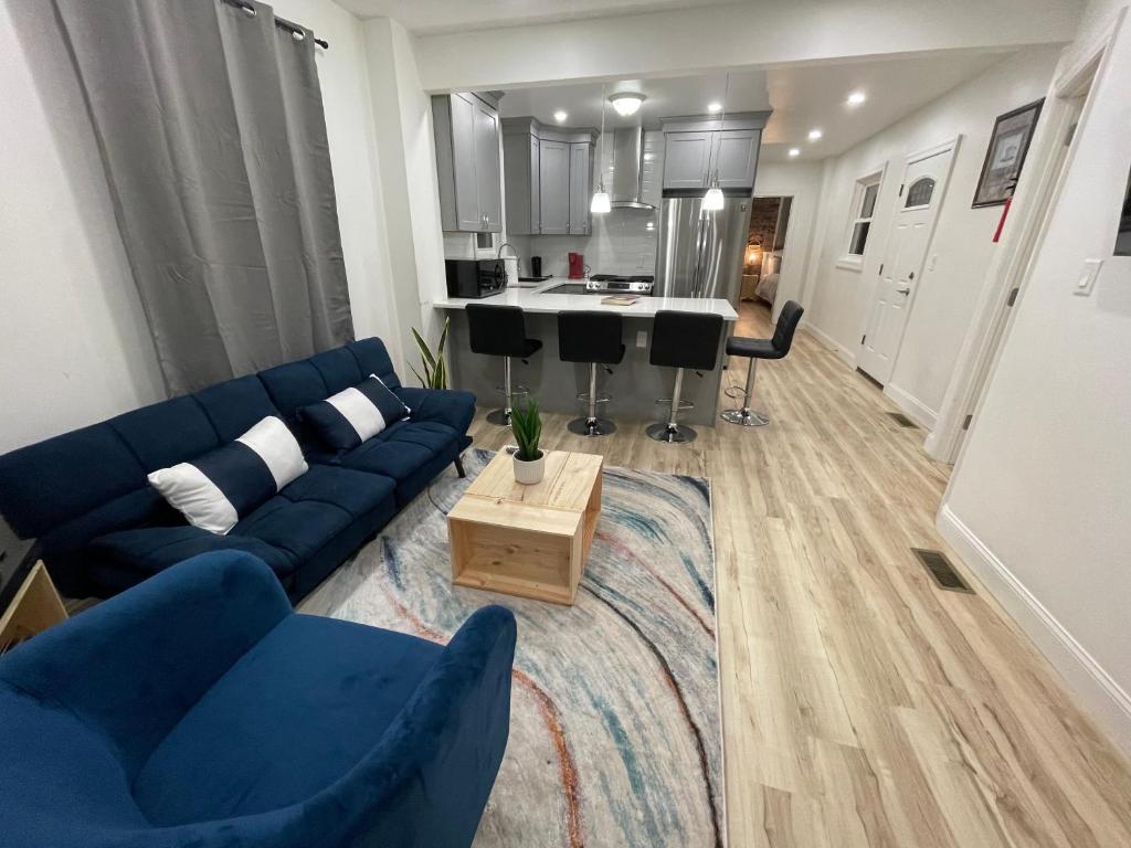 a living room with a blue couch and a kitchen at Modern Luxury Apartment near NYC in Jersey City