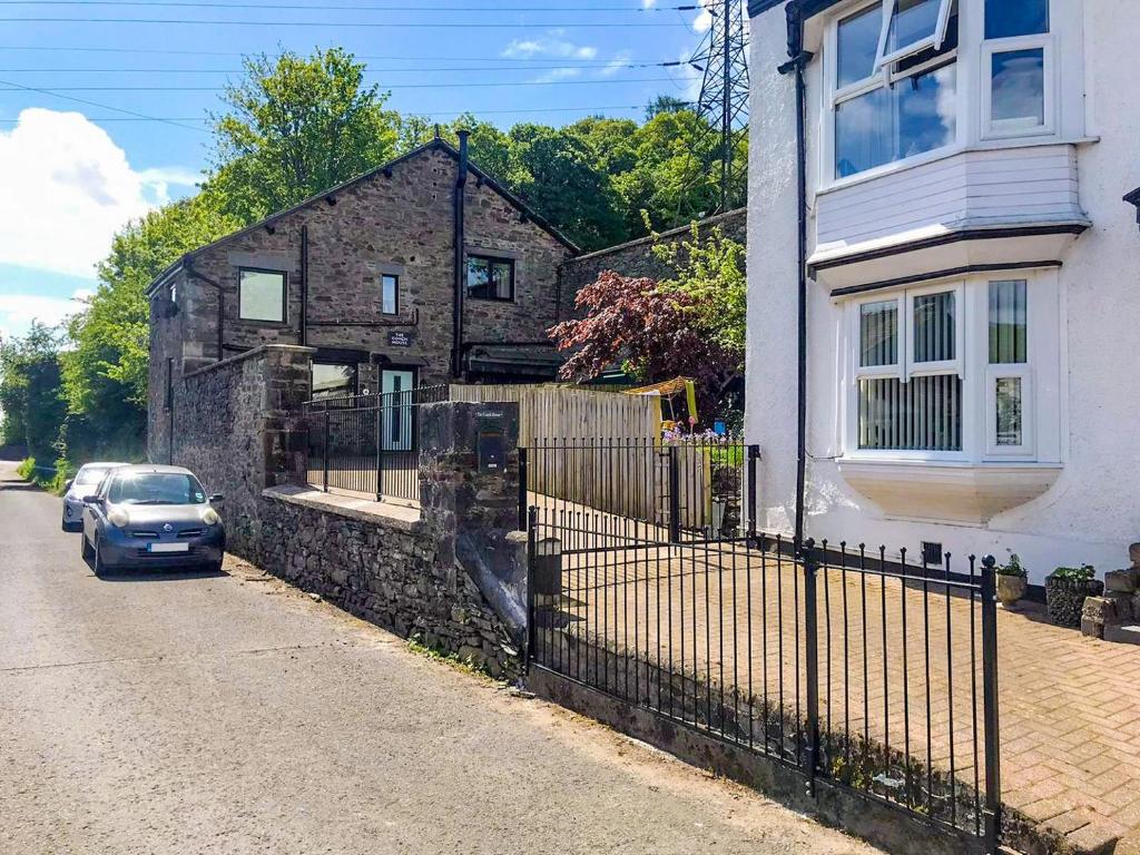 a car parked in front of a stone house at The Coach House in Greenodd