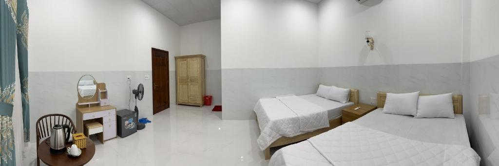 um quarto branco com uma cama e um espelho em Thanh Mai House Phú Quốc em Phu Quoc