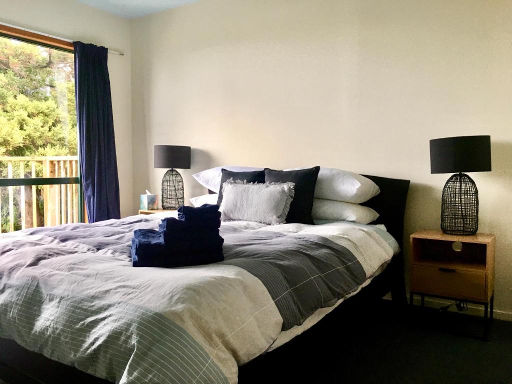 a bedroom with a bed with pillows and a window at Panoramic Views - House in Ahipara