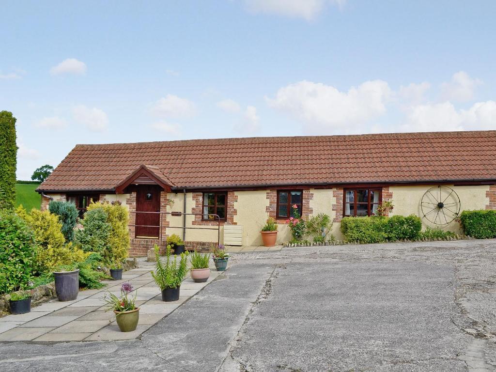 a house with potted plants in front of it at Parlour Cottage in Evershot