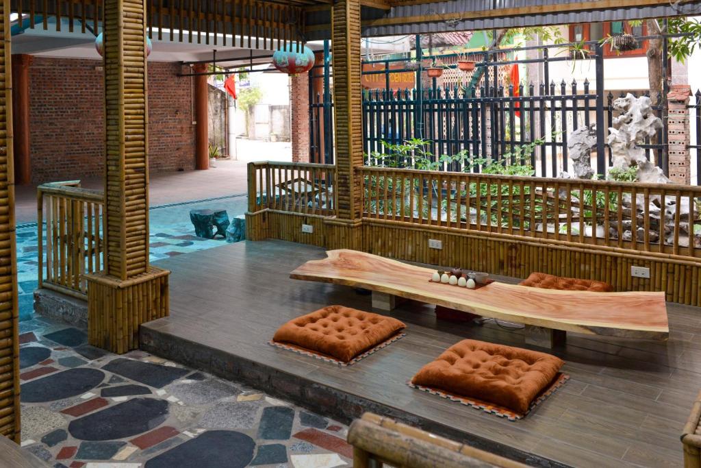 un banco de madera sentado en la parte superior de un suelo de madera en City Garden Hostel en Ninh Binh