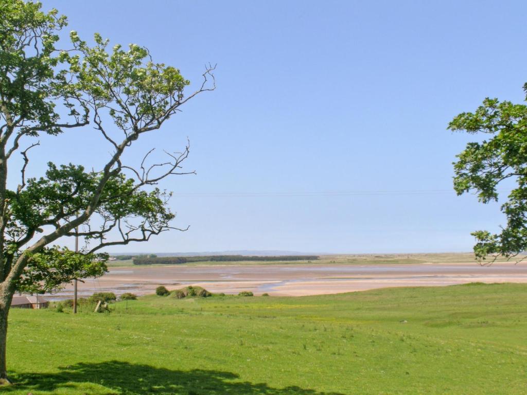 a view of a river with trees in the foreground at Beach View in Bamburgh