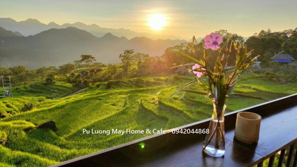 a vase with flowers on a balcony with a view at Pu Luong May Home & Cafe in Làng Bang
