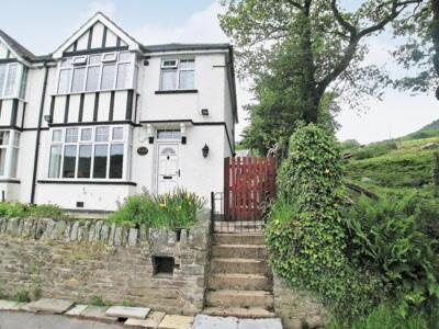 a large white house with a red gate and stairs at Tyn Y Graig Cottage in Crynant