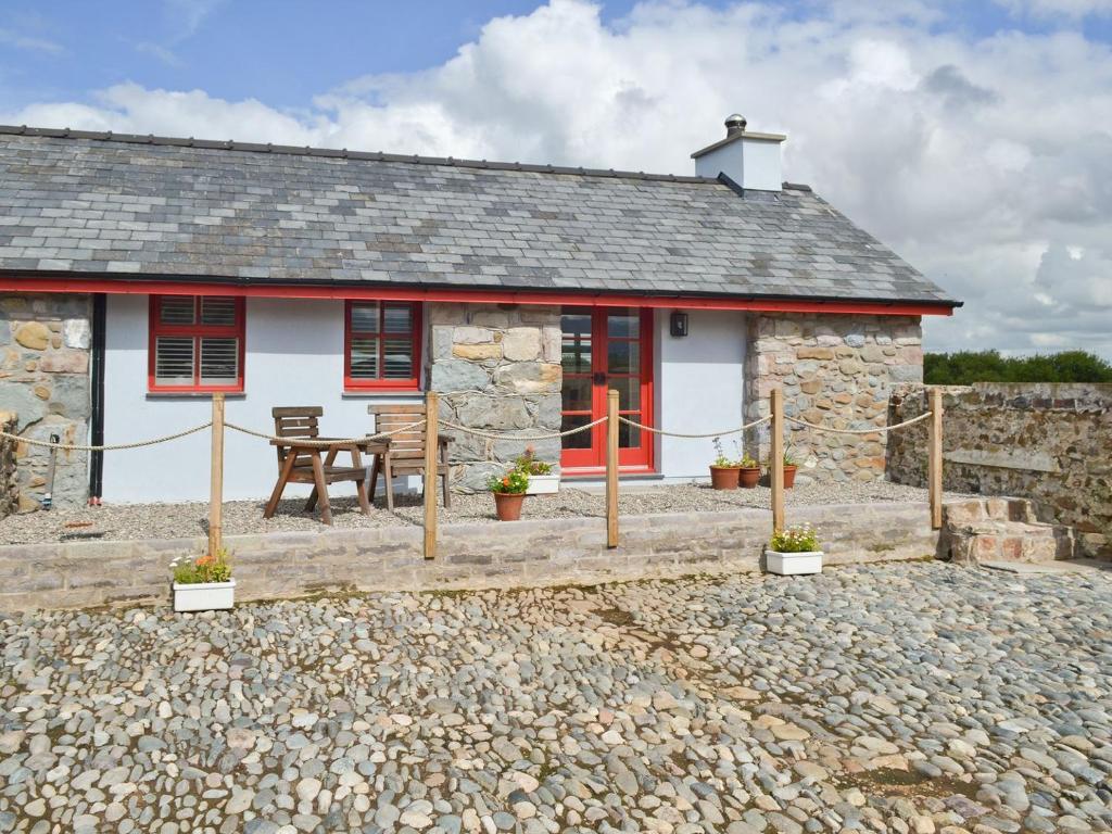 a stone cottage with a picnic table in front of it at Ty Macsen in Llanwnda