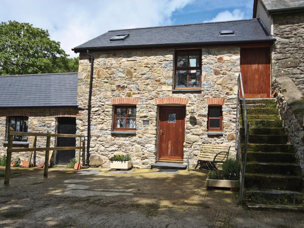a stone house with a wooden door and windows at The Stable - Hw7461 in Henrys Moat