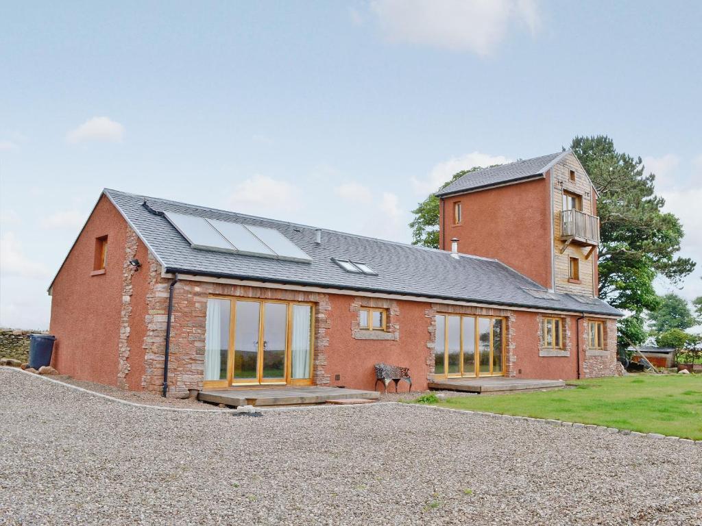 a red brick house with solar panels on it at The Water Tower in Auchmithie