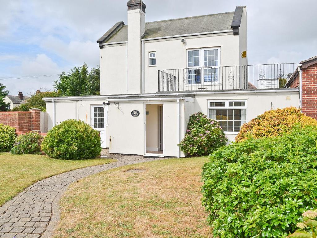 a white house with a walkway in front of it at Dune Cottage in Caister-on-Sea