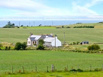 a house in the middle of a green field at Wee Dug Hoose in Glenluce