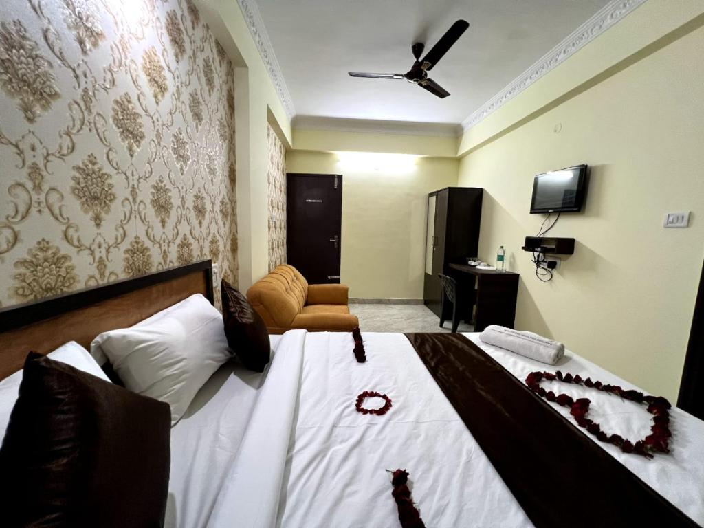 a bedroom with a bed with white sheets and a ceiling at Hotel East park Electronic City in Bangalore