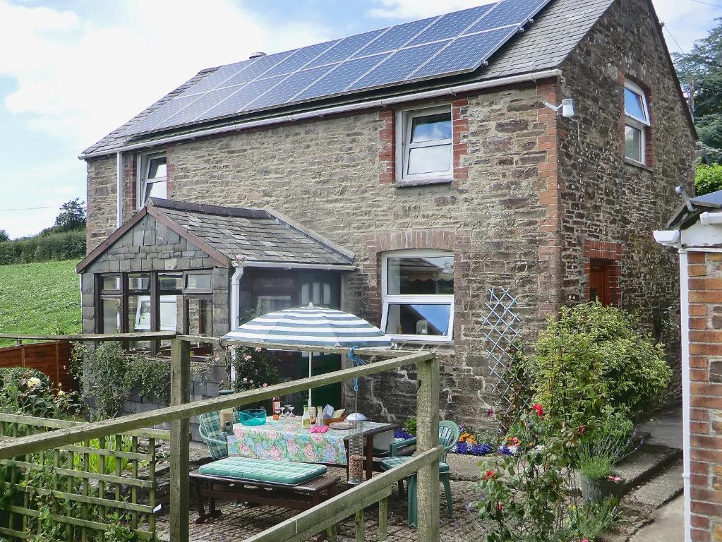 a brick house with solar panels on the roof at The Stables in Dunterton