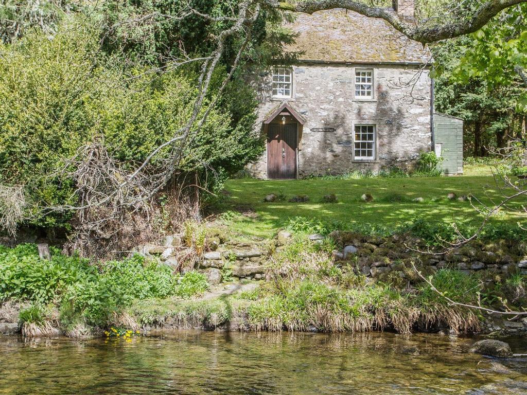 uma antiga casa de pedra ao lado de um rio em Gardeners Bothy em Balnaboth