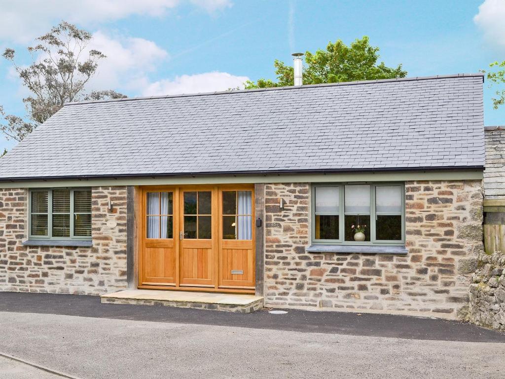 a brick house with a wooden door at The Wagon House in Luxulyan