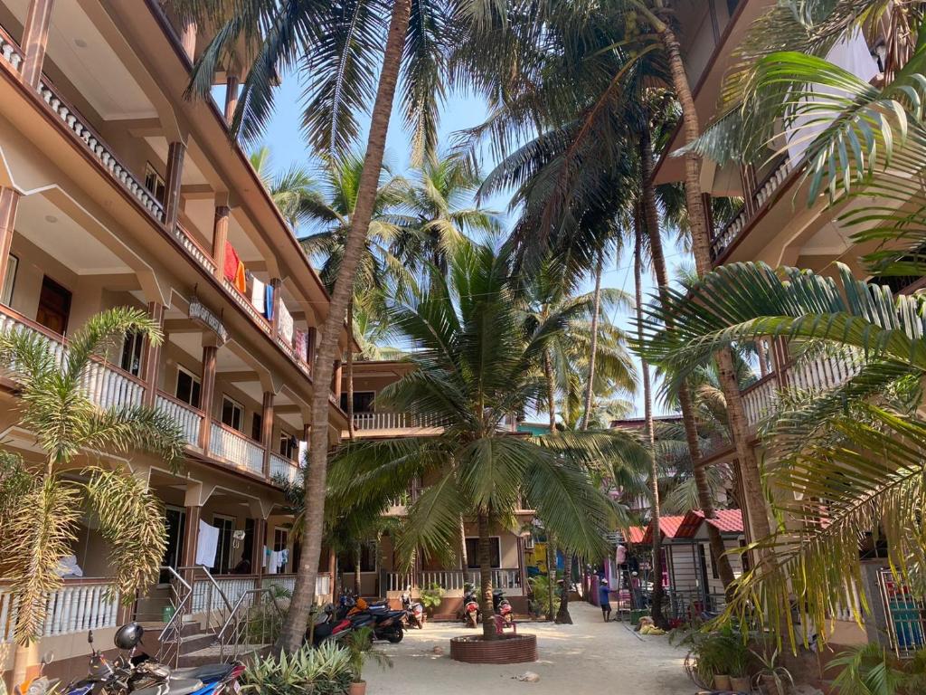 a courtyard with palm trees in a building at Gods gift guesthouse in Arambol