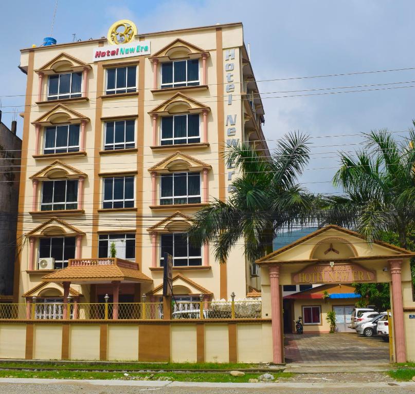 Butwāl的住宿－Hotel New Era，一座黄色的大建筑,上面有标志