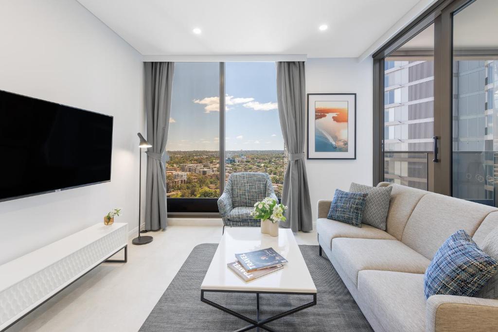 a living room with a couch and a tv at Meriton Suites George Street, Parramatta in Sydney