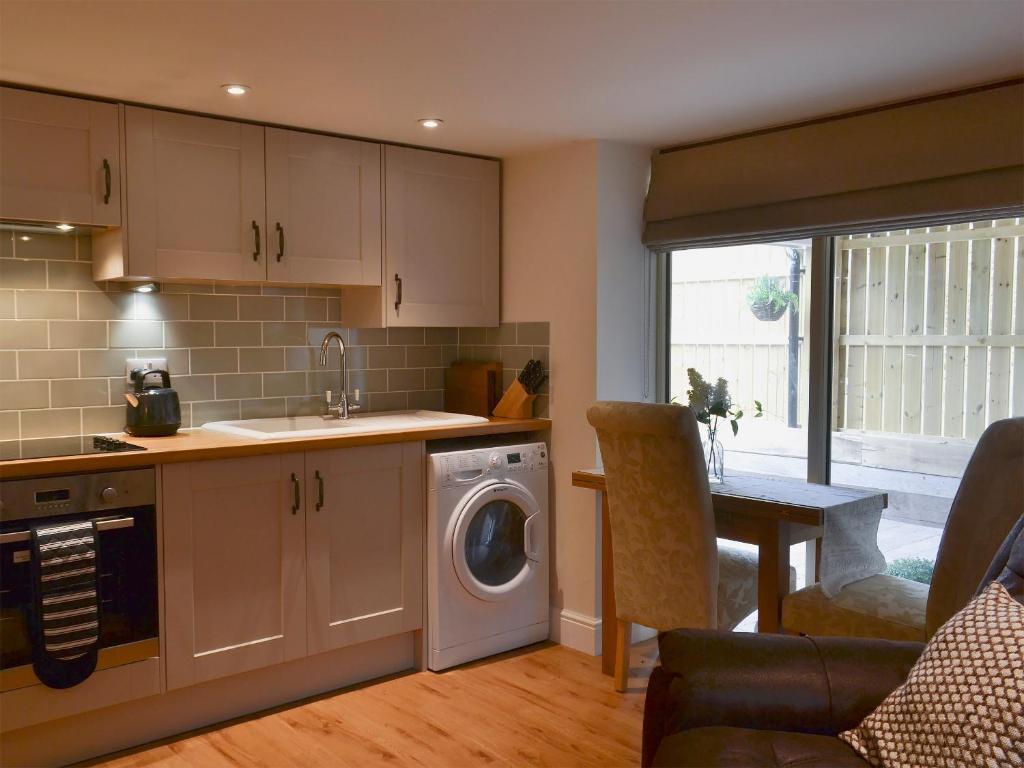 cocina con lavadora y secadora en una habitación en The Hayloft, en Hunstanton