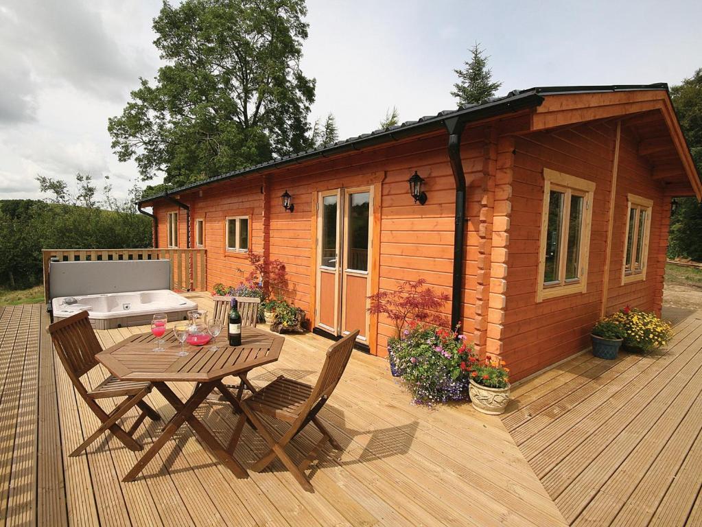 a small cabin with a table and chairs on a deck at The Larches - E4651 in Mainstone