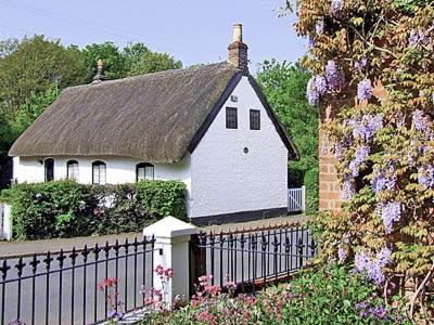 una casa blanca con techo y valla en Childe Of Hale Cottage - 27896 en Hale