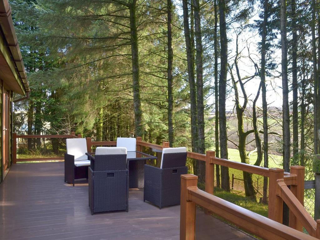 una terraza con sillas y una mesa en un porche en Oak Lodge, en Clatworthy