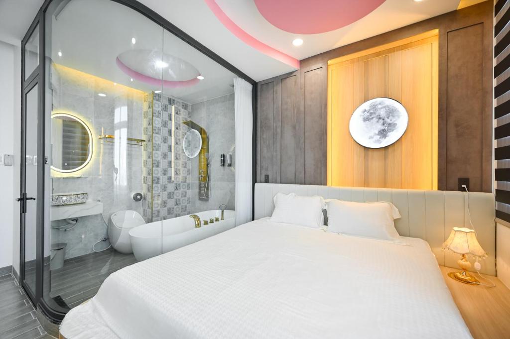 1 dormitorio con 1 cama blanca grande y baño en Lotus Airport Hotel Saigon en Ho Chi Minh