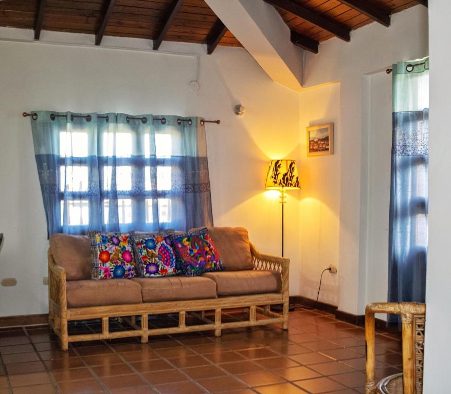 L Otro Pueblo Pampatar في Pampatar: غرفة معيشة مع أريكة ومصباح